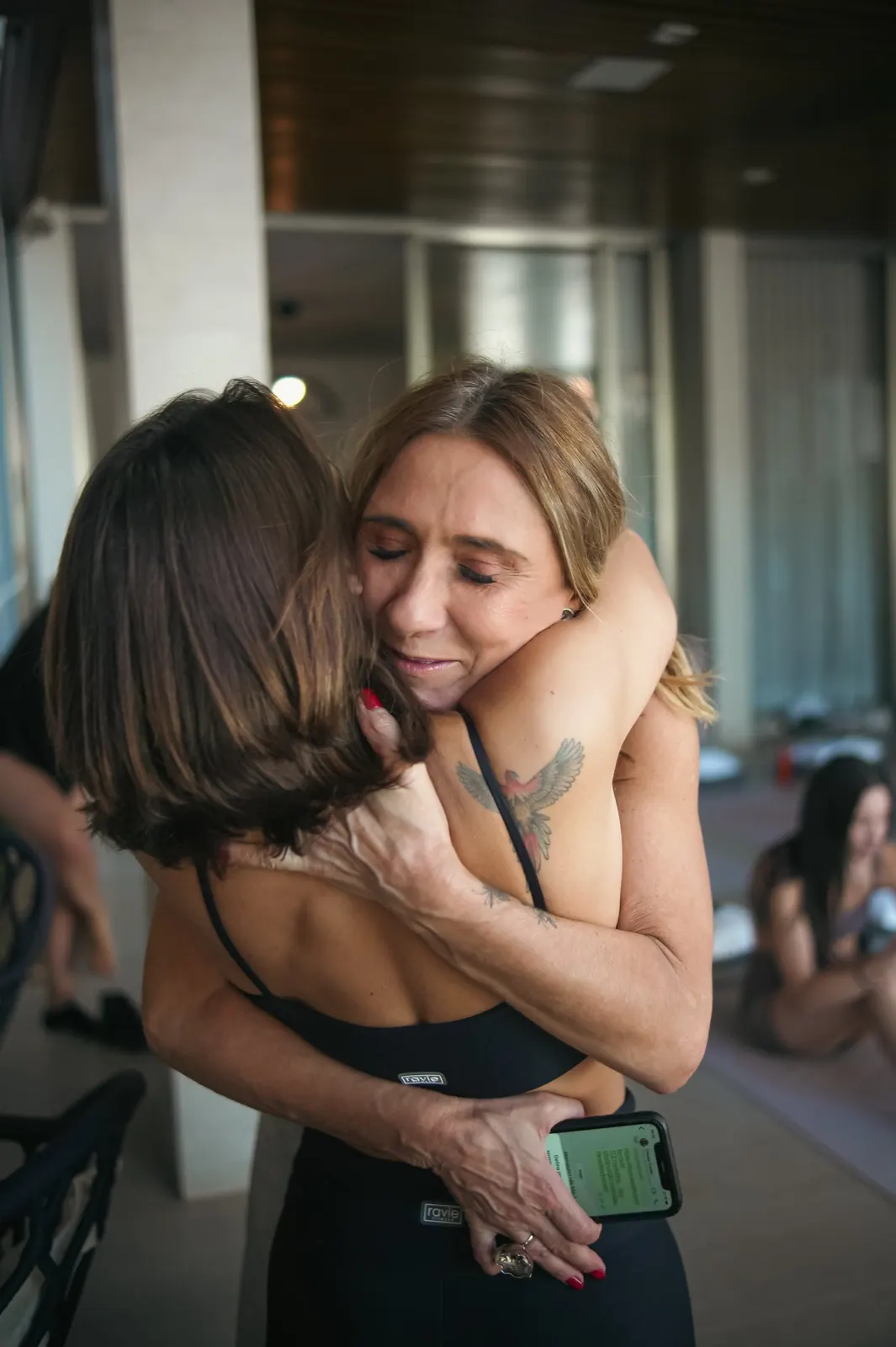 Duas mulheres se abraçando num encontro Somos Muitas